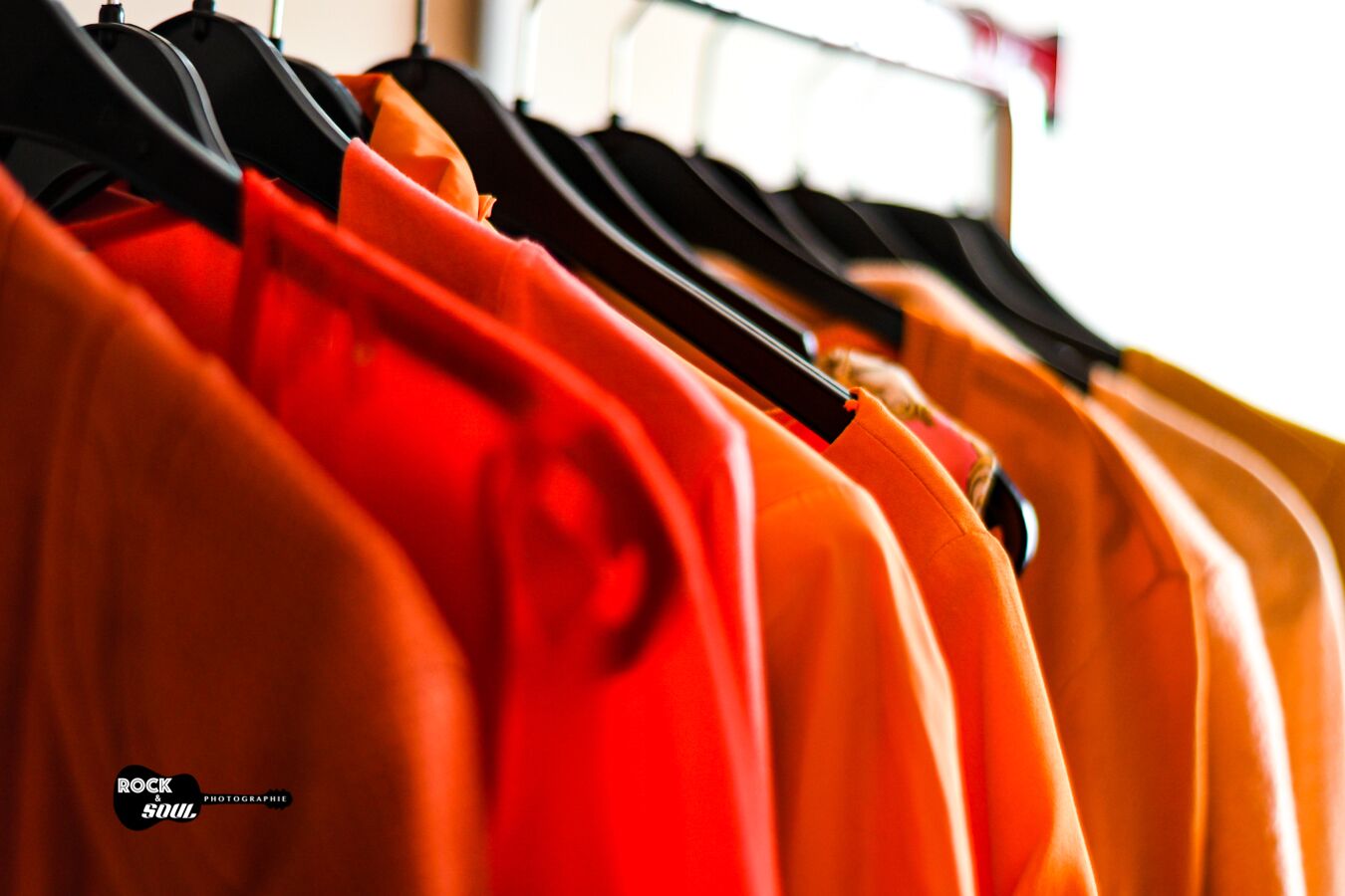 Kleidung orange auf Kleiderstange